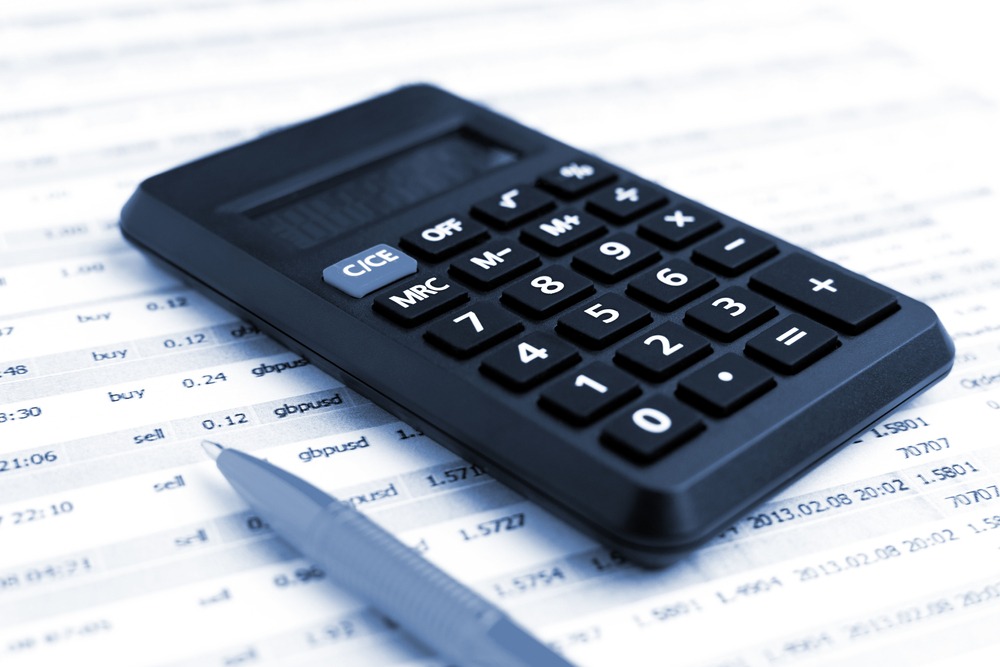 Nahaufnahme eines Taschenrechners und Stifts auf einem Finanzbericht