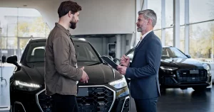 Beratungsgespräch zwischen Autohändler und Kunde im Autohaus