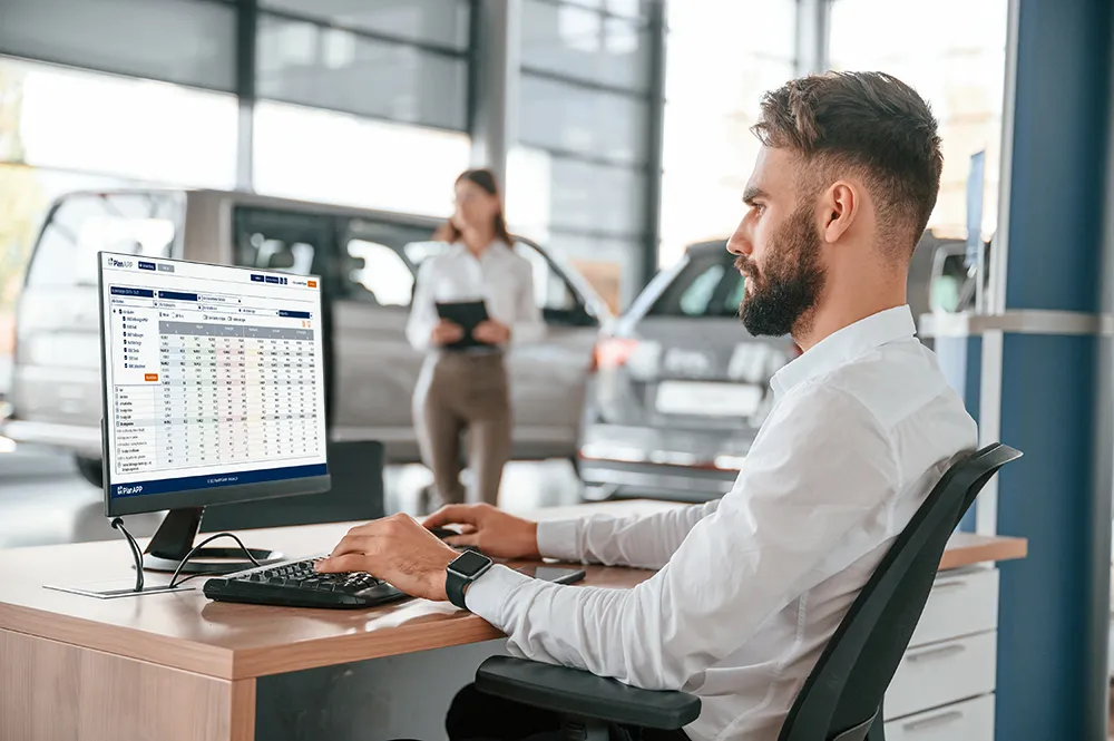 Autohaus-Mitarbeiter arbeitet am Computer mit Auswertungen von PlanApp